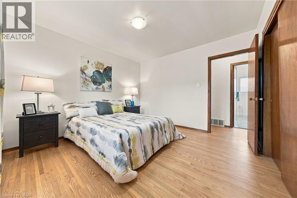 Wood-finish flooring throughout, white walls, and a ceiling-mounted light fixture - 662 Dynes Road, Burlington, ON