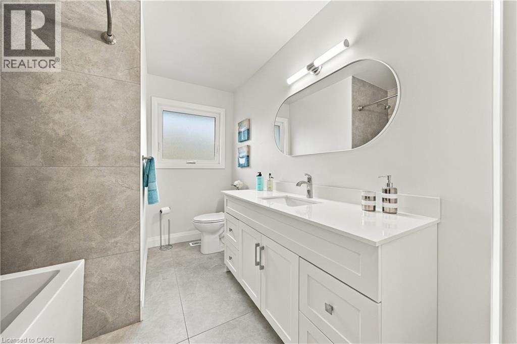 White vanity with a quartz countertop, rectangular undermount sink, and chrome faucet - 662 Dynes Road, Burlington, ON