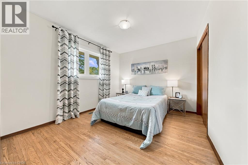 Hardwood-style flooring throughout, light-toned walls, and a window with natural light - 662 Dynes Road, Burlington, ON