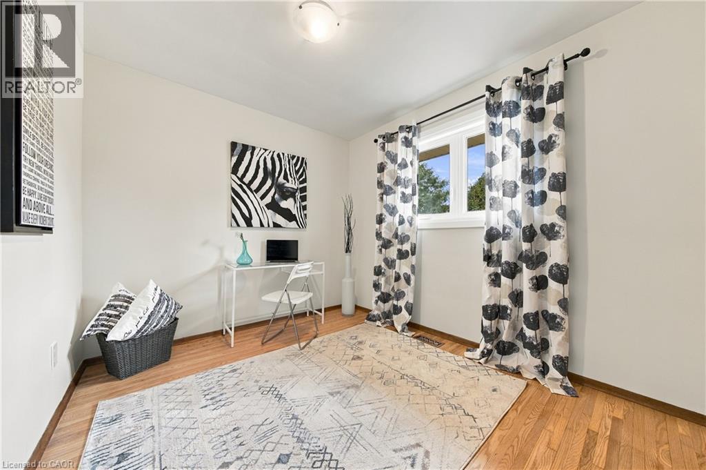 Wood-finish flooring, white walls, and a window with white trim - 662 Dynes Road, Burlington, ON