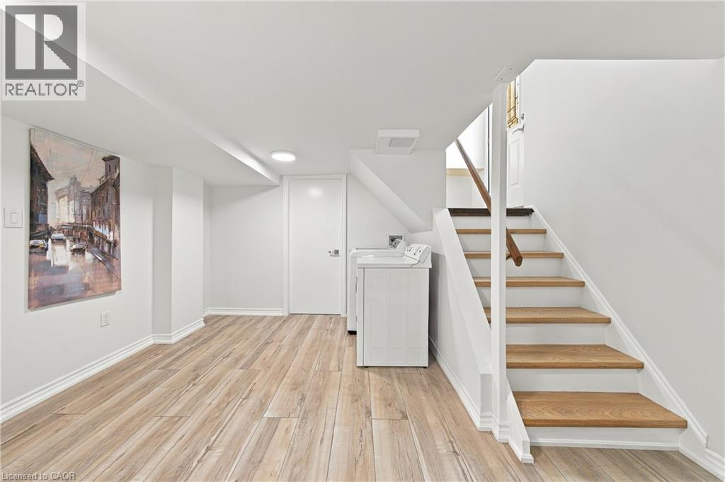 Wood-finish flooring, white painted walls, recessed lighting, and a straight staircase with a wooden handrail - 662 Dynes Road, Burlington, ON