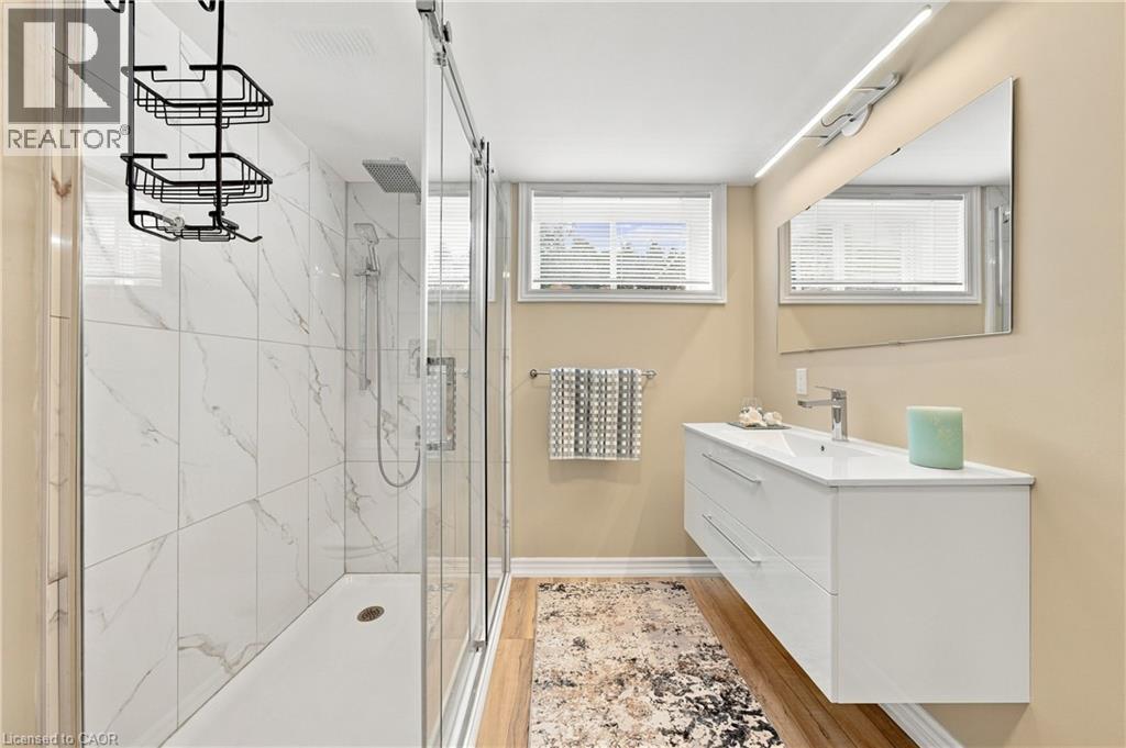 Shower with white large-format tiled walls and glass sliding door - 662 Dynes Road, Burlington, ON