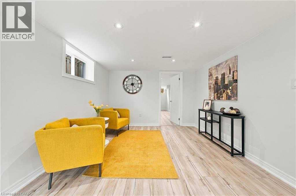 Recessed lighting, wood-finish flooring, white walls, and a white door frame define this living space - 662 Dynes Road, Burlington, ON