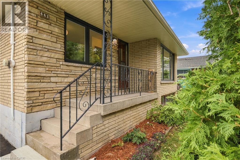 Stacked stone and brick-finish exterior with dark-framed windows - 662 Dynes Road, Burlington, ON