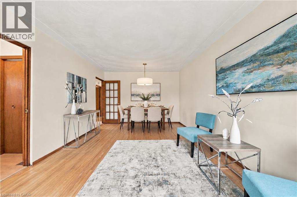 Wood-finish flooring throughout, crown molding, and a dining area with a contemporary chandelier - 662 Dynes Road, Burlington, ON