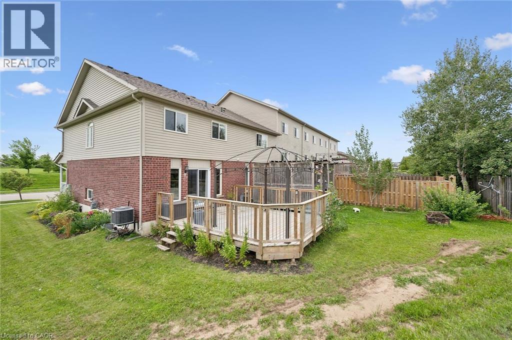 Expansive backyard featuring a multi-level wood deck, a partial privacy fence, and mature trees - 308 Parkvale Drive, Kitchener, ON