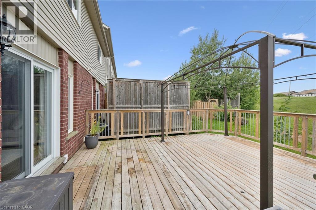 Expansive wood deck with a metal gazebo frame, wood railing, and brick exterior - 308 Parkvale Drive, Kitchener, ON