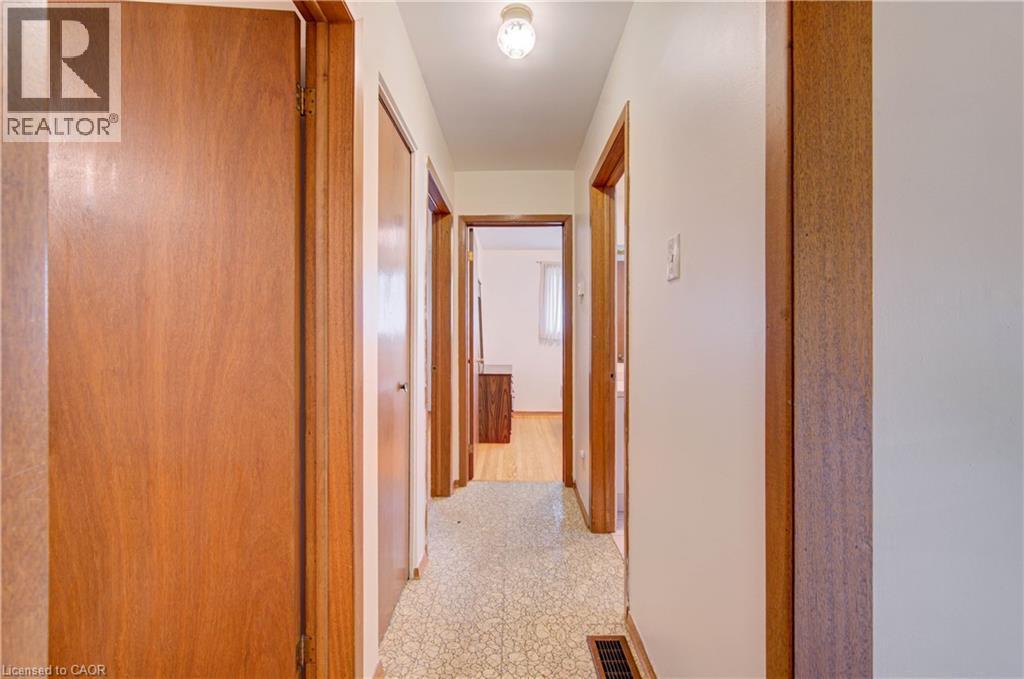Hallway with patterned flooring, light wood doors, and a ceiling-mounted light fixture - 465 Herkimer Street, Hamilton, ON
