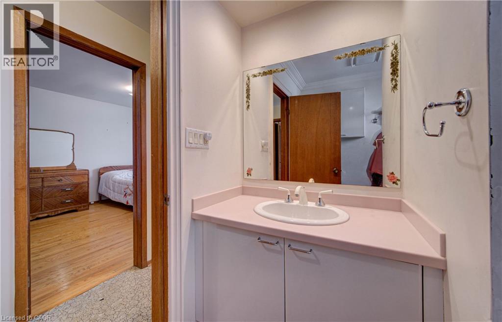 White vanity with built-in sink and pink countertop - 465 Herkimer Street, Hamilton, ON
