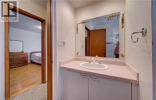 White vanity with built-in sink and pink countertop - 465 Herkimer Street, Hamilton, ON 