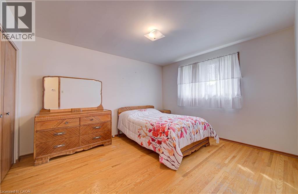 Hardwood flooring throughout, neutral wall finishes, flush mount ceiling light, and a window with natural light - 465 Herkimer Street, Hamilton, ON