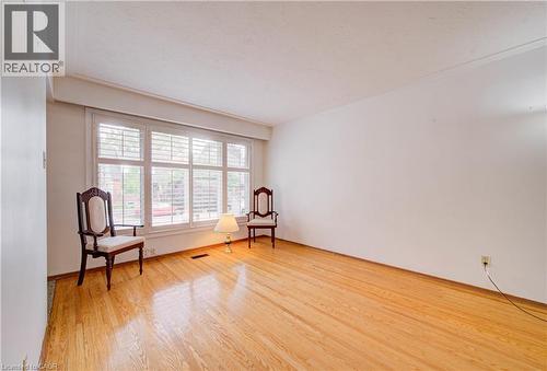 Hardwood flooring, white walls, and a large window with plantation shutters - 465 Herkimer Street, Hamilton, ON 