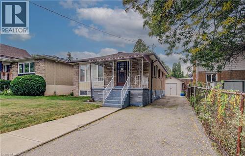 Brick and stone exterior with a covered porch, white railing, and concrete steps - 465 Herkimer Street, Hamilton, ON 