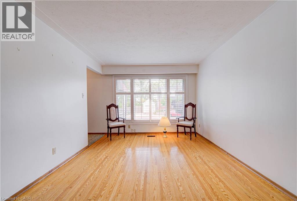 Hardwood flooring, painted walls, white trim, and window with horizontal blinds - 465 Herkimer Street, Hamilton, ON