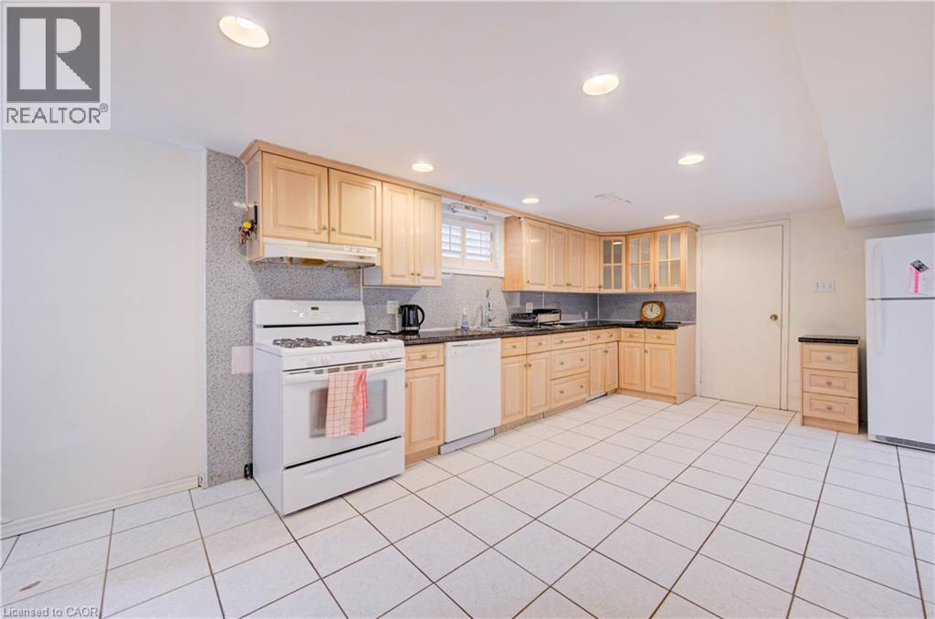 Kitchen featuring wood cabinetry, white tile flooring, recessed lighting, a built-in dishwasher, and a gas range - 465 Herkimer Street, Hamilton, ON