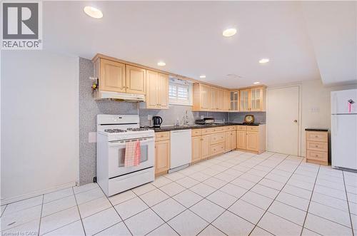 Kitchen featuring wood cabinetry, white tile flooring, recessed lighting, a built-in dishwasher, and a gas range - 465 Herkimer Street, Hamilton, ON 