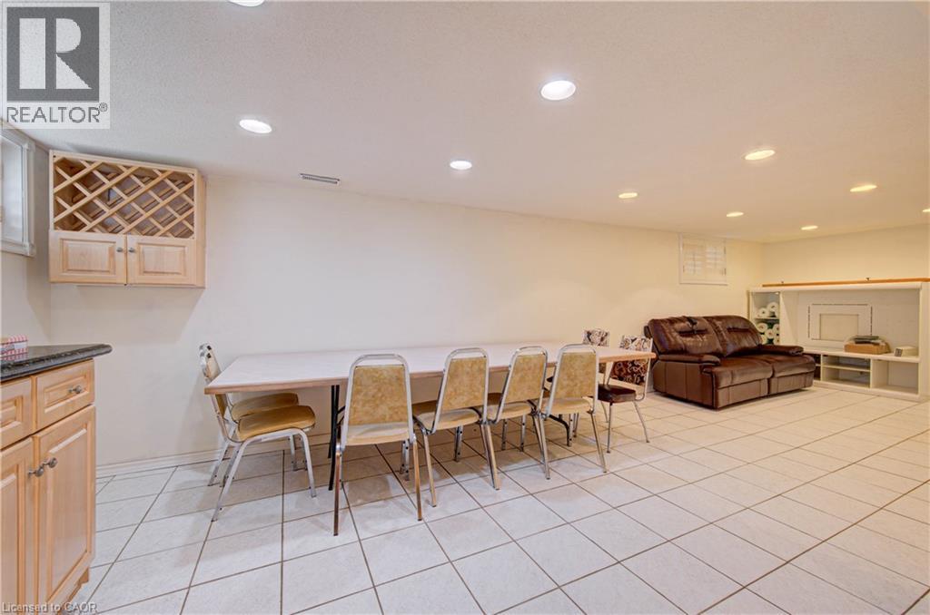 Recessed lighting, tile flooring, built-in cabinetry with wine storage, and a built-in media console with shelving - 465 Herkimer Street, Hamilton, ON