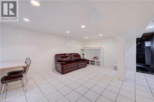 Recessed lighting illuminating the white ceiling, white ceramic tile flooring, and white painted walls, with a built-in media console - 465 Herkimer Street, Hamilton, ON 