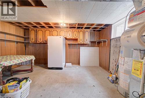 Basement utility space featuring a drop ceiling, wood paneling, and concrete flooring - 465 Herkimer Street, Hamilton, ON 