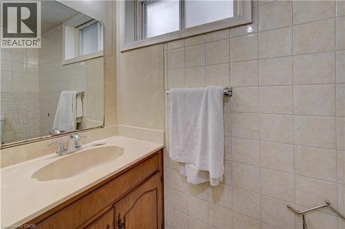Integrated vanity with an oval basin, chrome faucet, and wood-finish cabinetry - 465 Herkimer Street, Hamilton, ON 