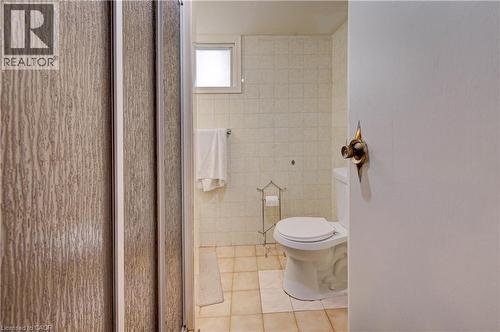 Frosted shower enclosure with light-toned tile flooring, and wall-mounted towel bar - 465 Herkimer Street, Hamilton, ON 