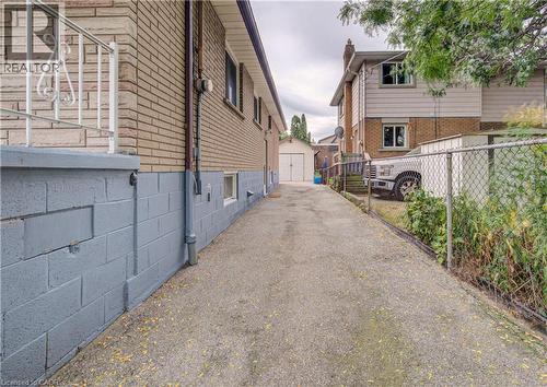 Paved driveway leading to a detached garage with double doors - 465 Herkimer Street, Hamilton, ON 