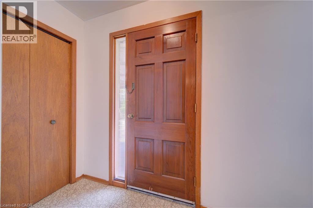 Wood-paneled entry door with sidelight and gold-toned hardware - 465 Herkimer Street, Hamilton, ON