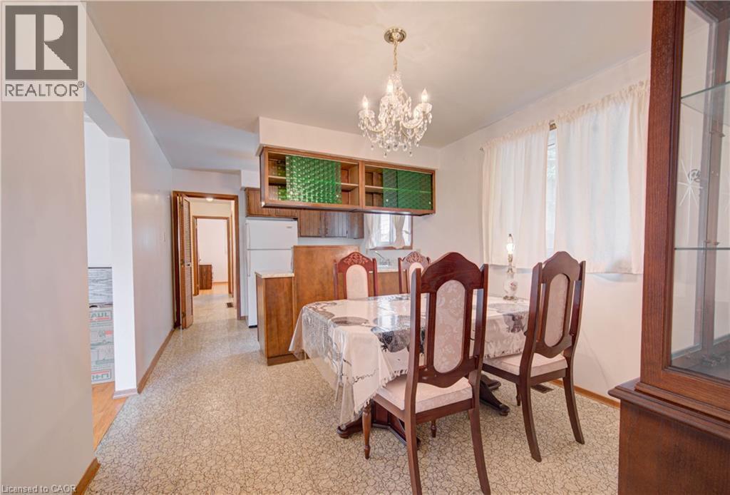 Recessed wall cabinetry with clear glass panels, crystal chandelier, and wood-finish flooring - 465 Herkimer Street, Hamilton, ON