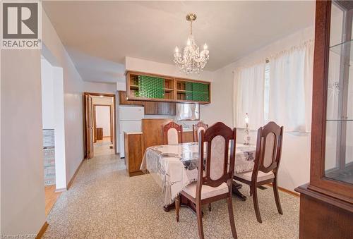 Recessed wall cabinetry with clear glass panels, crystal chandelier, and wood-finish flooring - 465 Herkimer Street, Hamilton, ON 