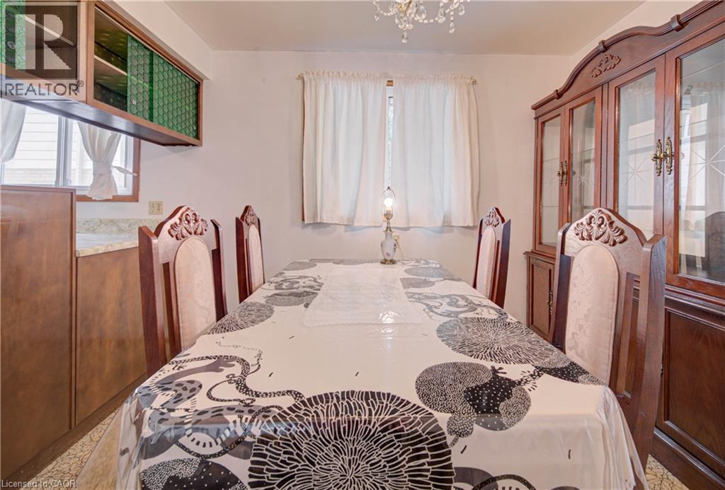 Elegant dining area featuring a crystal chandelier and window with natural light - 465 Herkimer Street, Hamilton, ON