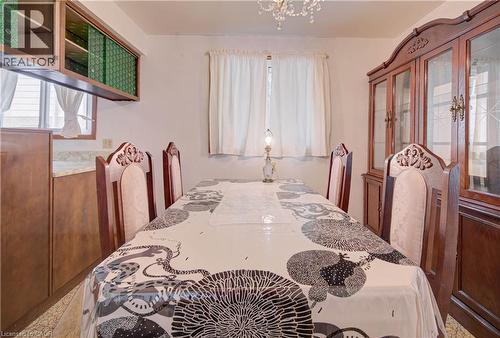 Elegant dining area featuring a crystal chandelier and window with natural light - 465 Herkimer Street, Hamilton, ON 