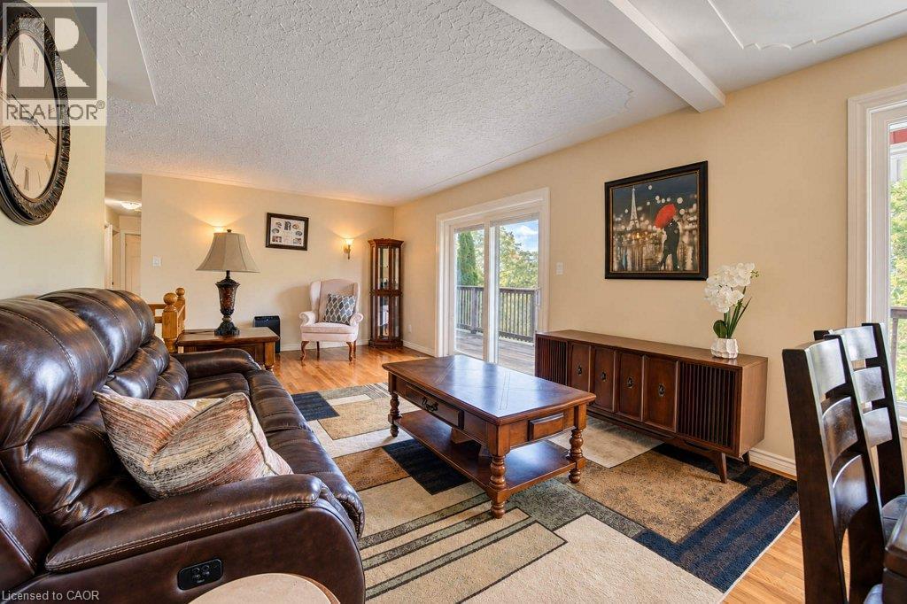 Exposed ceiling beams, wood-finish flooring, sliding glass patio door, and recessed lighting - 1370 Thorman Place, Cambridge, ON
