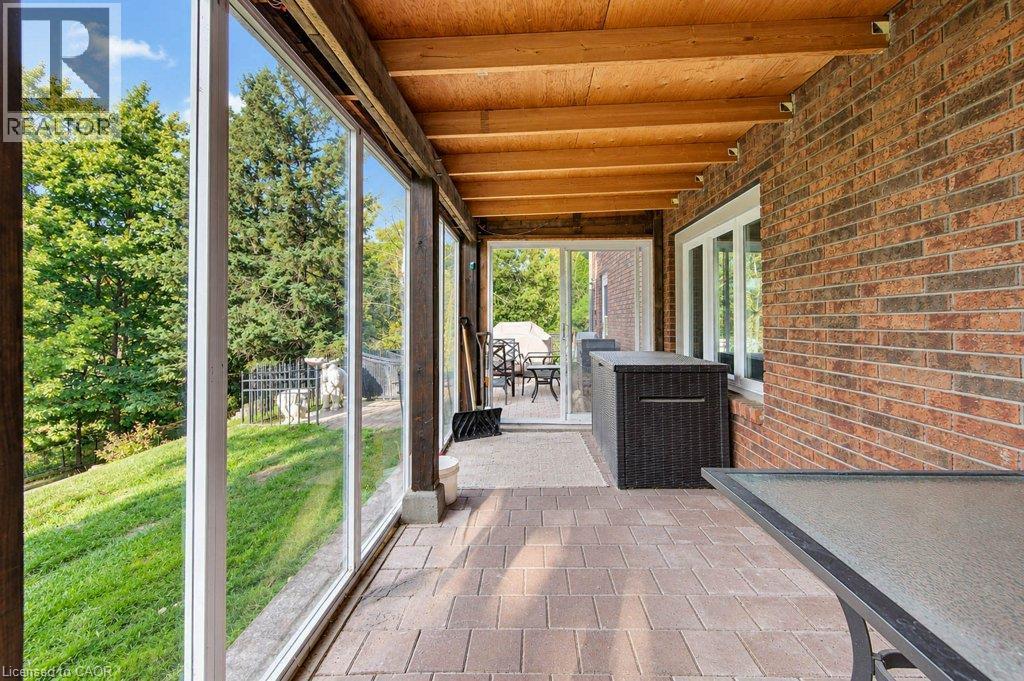Covered patio with a wood-finish ceiling, brick exterior wall, and paver flooring - 1370 Thorman Place, Cambridge, ON