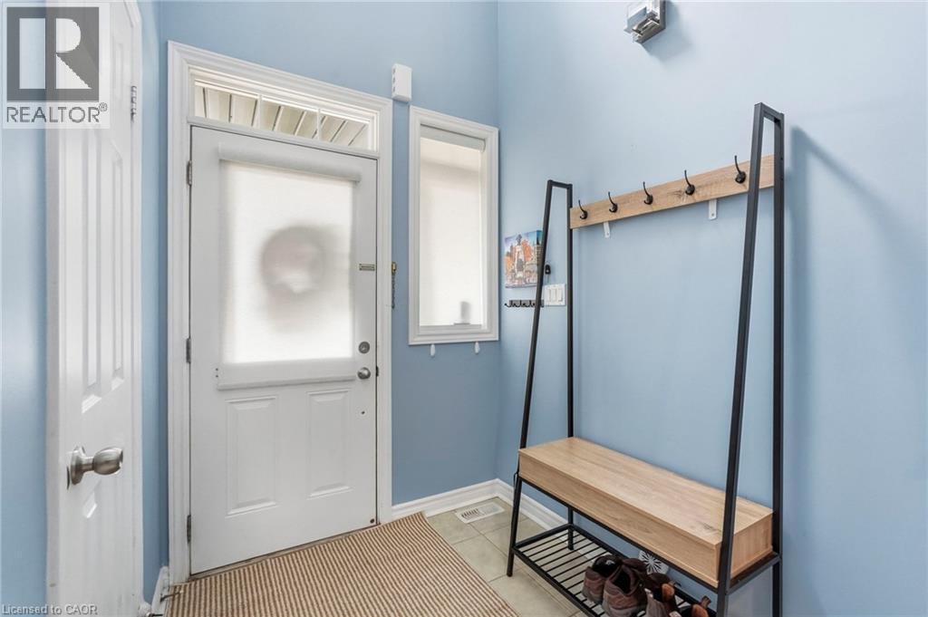 Entryway featuring a white door, transom window, and an additional side window - 1076 Ryckman Common, Burlington, ON