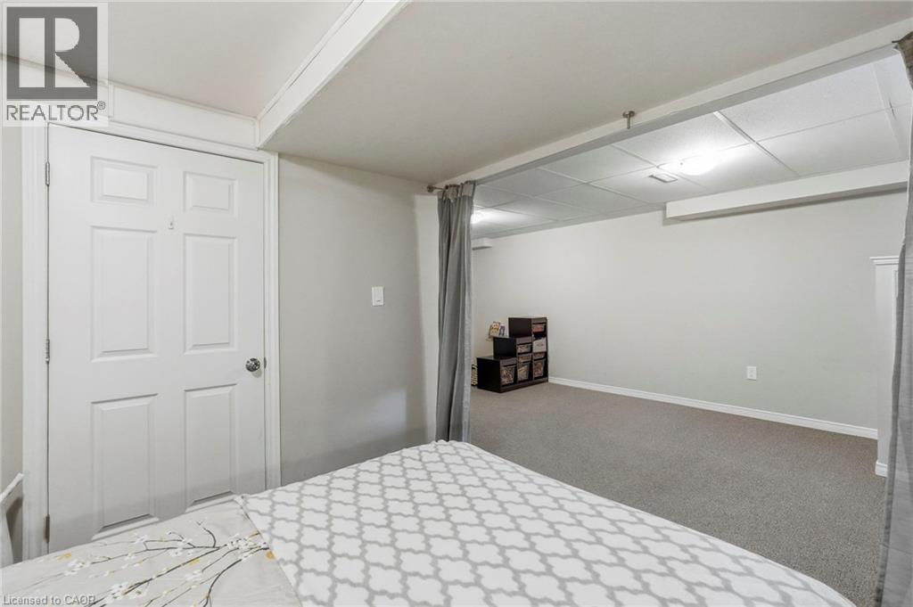 Recessed lighting illuminates the space, featuring light gray wall paint and gray carpeting - 1076 Ryckman Common, Burlington, ON