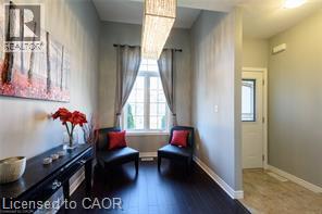 Wood-finish flooring, central window with grid pattern, and a prominent rectangular light fixture - 28 Madonna Drive, Hamilton, ON