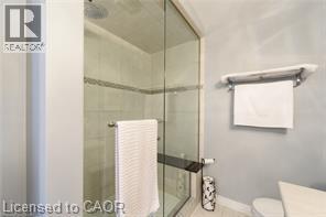 Glass-enclosed shower with tile surround and integrated shelving - 28 Madonna Drive, Hamilton, ON