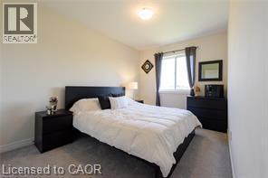 Wall-to-wall carpeting with light-toned walls and a window with dark drapery - 28 Madonna Drive, Hamilton, ON
