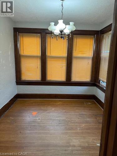 Wood-finish flooring, dark wood window trim, and a chandelier with glass shades - 255 Main Street, Cambridge, ON 