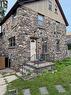 Stone facade exterior with an arched entryway, gabled roofline, and multiple windows - 255 Main Street, Cambridge, ON 