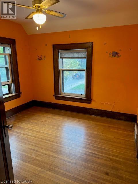 Hardwood flooring, two windows with wood trim, ceiling fan light fixture, and wood baseboards - 255 Main Street, Cambridge, ON