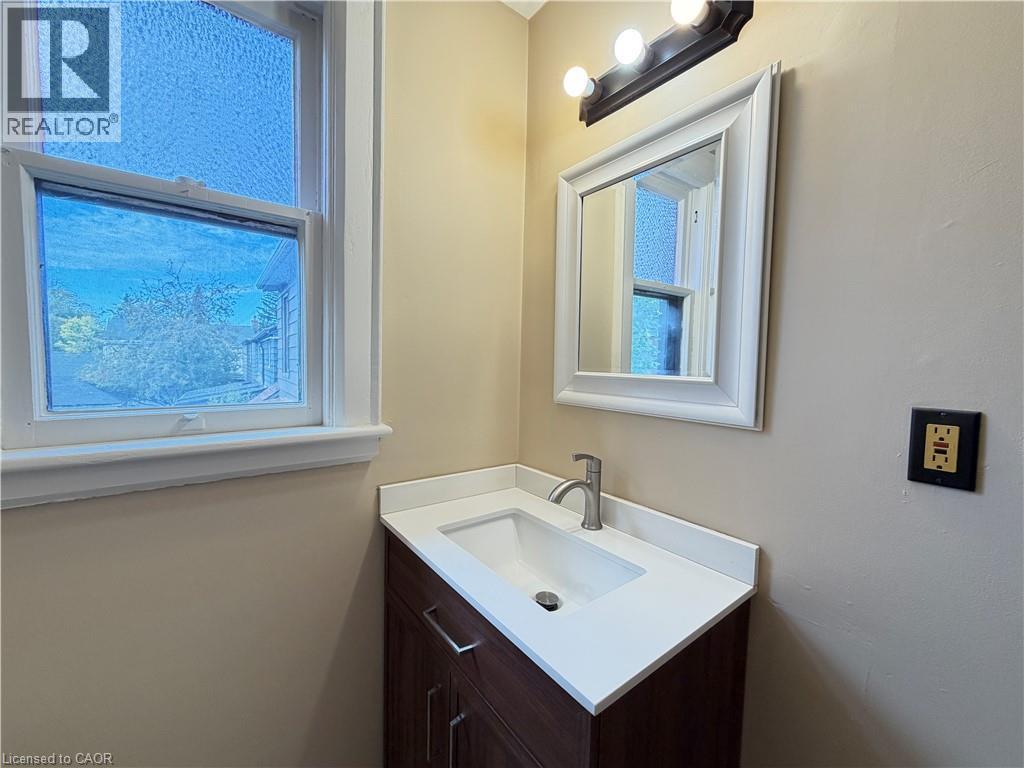 Modern vanity with an integrated sink, white countertop, and brushed nickel faucet - 507 Aberdeen Avenue, Hamilton, ON