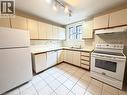 Kitchen featuring white cabinetry, a white electric range, a white dishwasher, and a white refrigerator - 507 Aberdeen Avenue, Hamilton, ON 