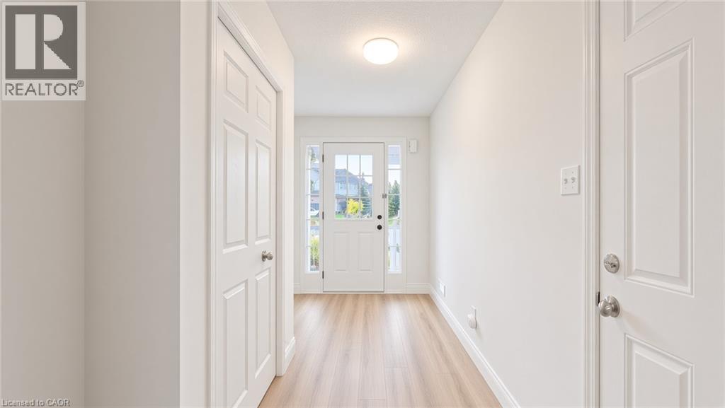 Entryway with light wood-finish flooring, white paneled doors, and a ceiling-mounted light fixture - 250 Parkvale Drive, Kitchener, ON