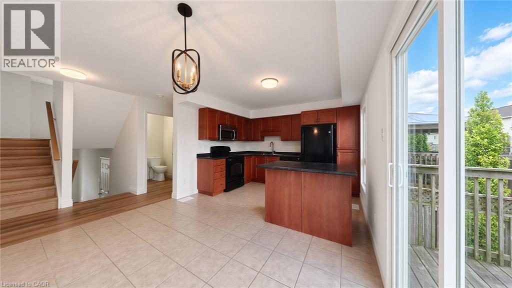 Open-concept kitchen with wood-finish cabinetry, black appliances, and island - 250 Parkvale Drive, Kitchener, ON