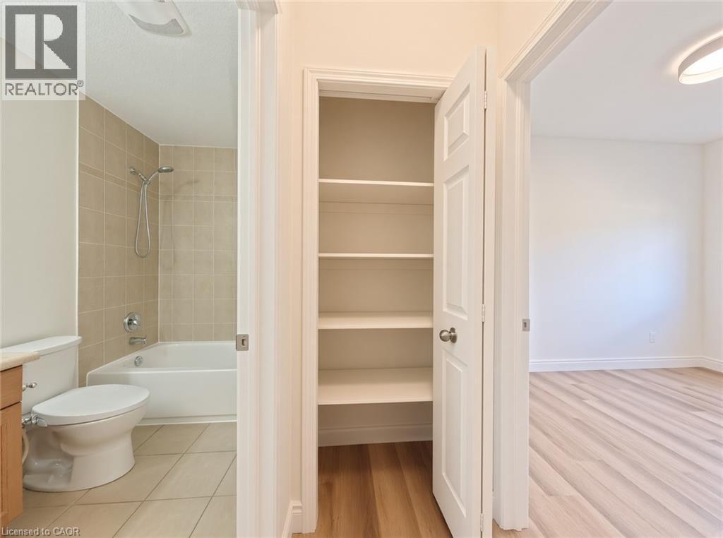 Bathroom featuring a white bathtub, ceramic wall tiling, and a toilet - 250 Parkvale Drive, Kitchener, ON