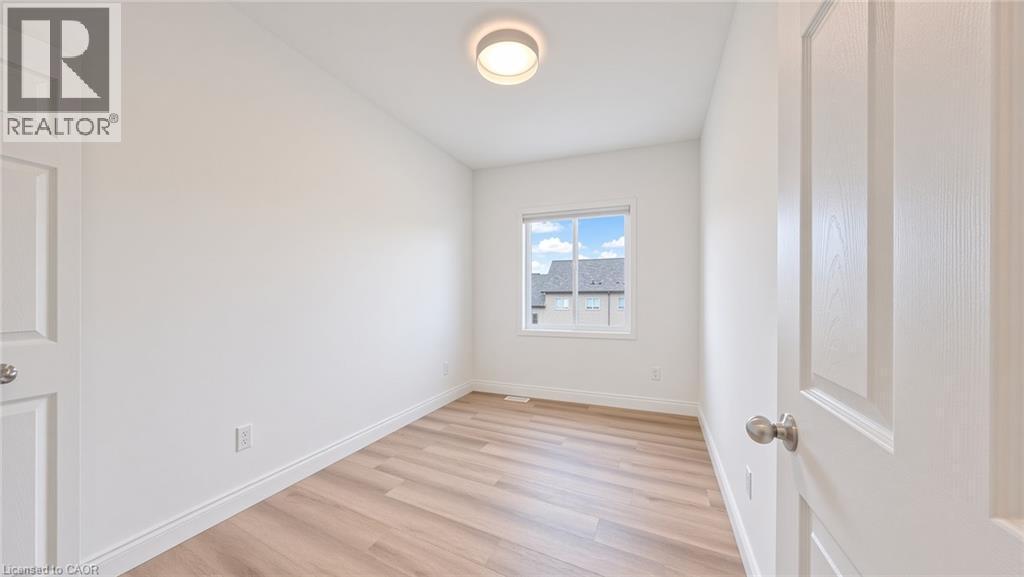 Bright room featuring light wood-finish flooring, white trim, and a window with a white frame - 250 Parkvale Drive, Kitchener, ON