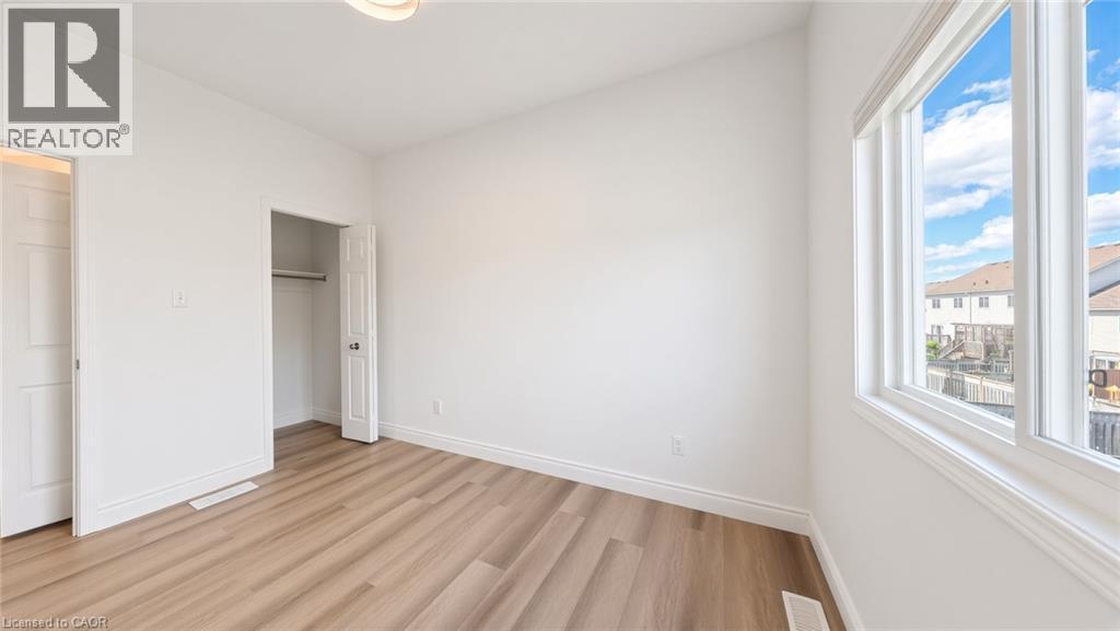 Bright interior with wood-finish flooring, white trim, and a built-in closet - 250 Parkvale Drive, Kitchener, ON