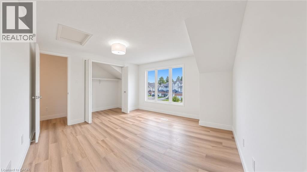 Bright room featuring wood-finish flooring, white walls, and a multi-pane window - 250 Parkvale Drive, Kitchener, ON