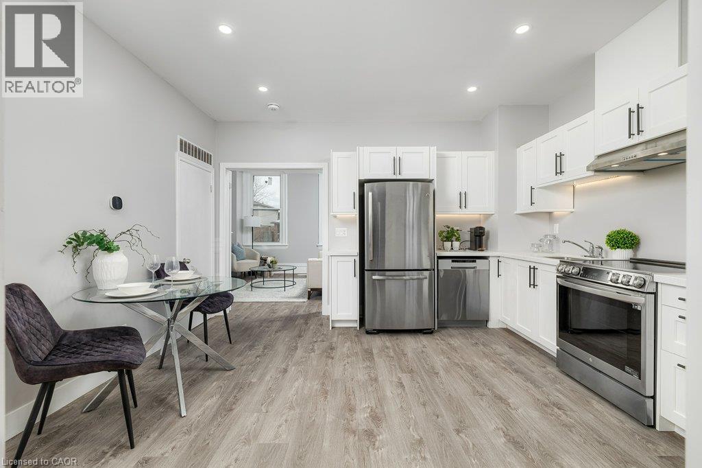Kitchen featuring white cabinetry, stainless steel appliances, recessed lighting, and wood-finish flooring - 125 Cathcart Street, Hamilton, ON